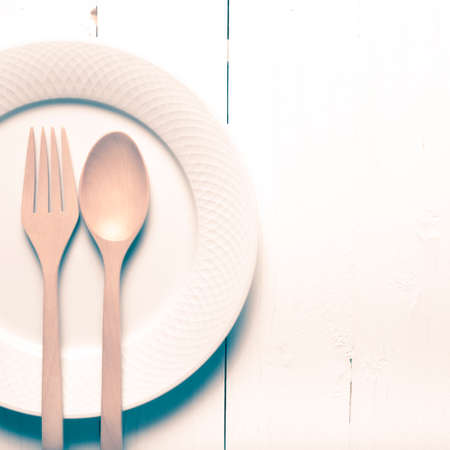 wood spoon and fork with dish over table background vintage styleの写真素材