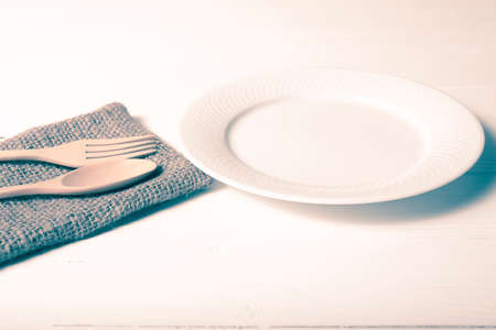 wood spoon and fork with dish over table background vintage styleの写真素材
