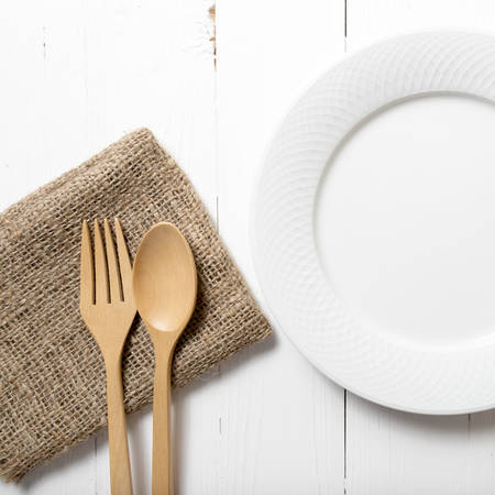 wood spoon and fork with dish over white table backgroundの写真素材
