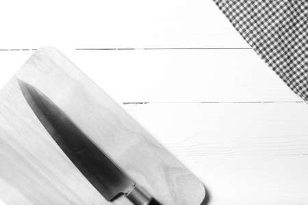 kitchen knife on cutting board over table background black and white tone color styleの写真素材