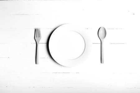 wood spoon and fork with dish over table background black and white tone color styleの写真素材