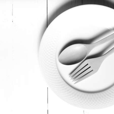 wood spoon and fork with dish over table background black and white tone color styleの写真素材