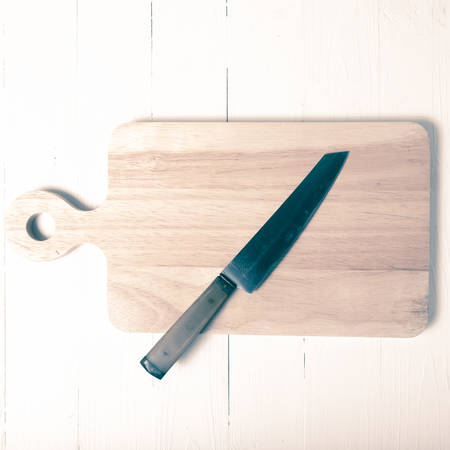 kitchen knife on cutting board over table background vintage styleの写真素材