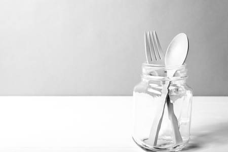 wood spoon and fork with glass over table black and white tone color styleの写真素材