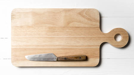 kitchen knife on cutting board over white table background