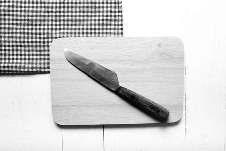 kitchen knife on cutting board over table background black and white tone color styleの写真素材
