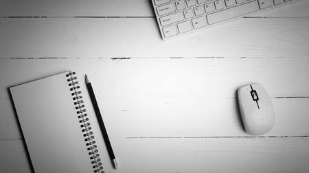 notepad and computer on white table background view from above black and white color styleの写真素材