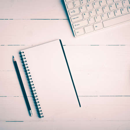 notepad and computer on white table background view from above vintage styleの写真素材