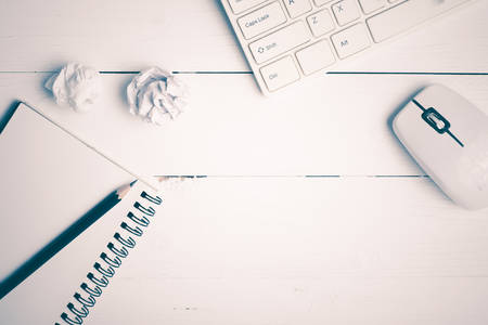 notepad and computer on white table background view from above vintage style