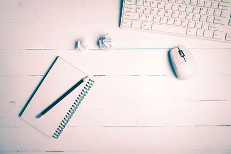 notepad and computer on white table background view from above vintage styleの写真素材