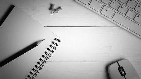 notepad and computer on white table background view from above black and white color styleの写真素材