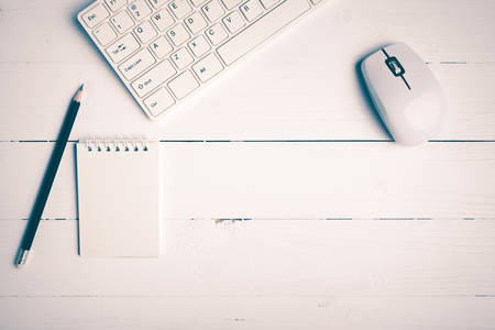notepad and computer on white table background view from above vintage style