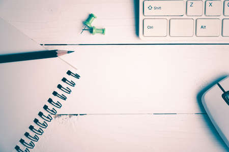 notepad and computer on white table background view from above vintage style