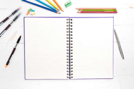 notepad with office supplies on white table view from aboveの写真素材