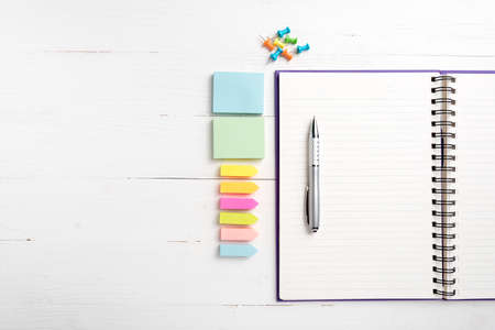 notepad with office supplies on white table view from aboveの写真素材
