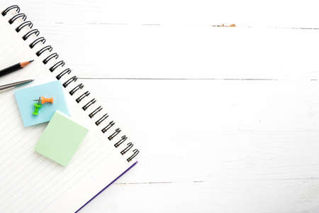 notepad with office supplies on white table view from aboveの写真素材