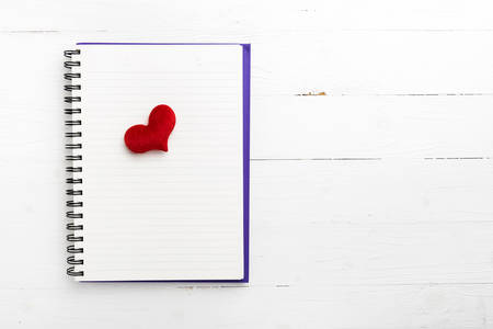 red heart on notepad on white tableの写真素材