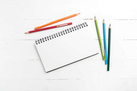 notepad with color pencil on white table view from aboveの写真素材