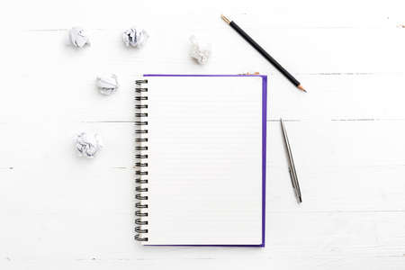 notepad and crumpled paper on white table