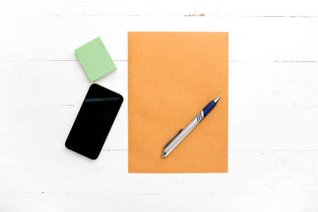 brown paper and smart phone on white tableの写真素材