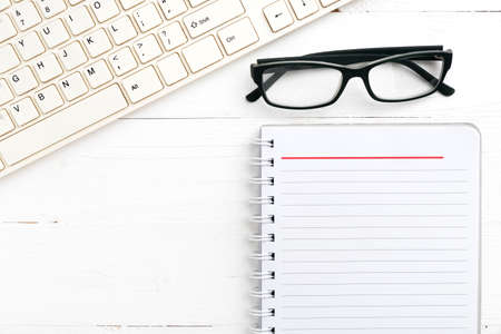 computer and notepad over white tableの写真素材