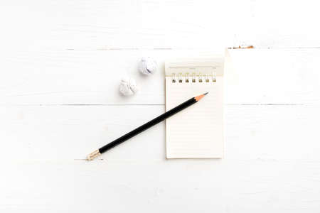 notepad with crumpled paper and pencil over white tableの写真素材