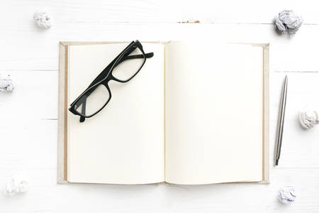 notebook and crumpled paper over white background