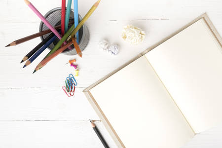 notebook with office supplies over white tableの写真素材
