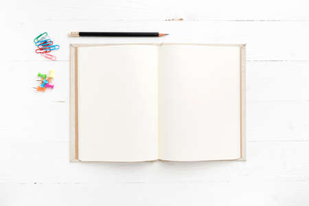notebook with office supplies over white tableの写真素材