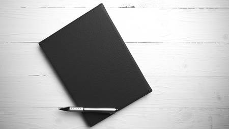 brown notebook and pen on white table view from above vintage styleの写真素材