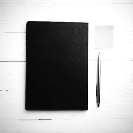 brown notebook and pen on white table view from above black and white tone color styleの写真素材