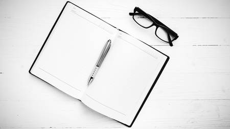 open notebook with pen on white table black and white styleの写真素材