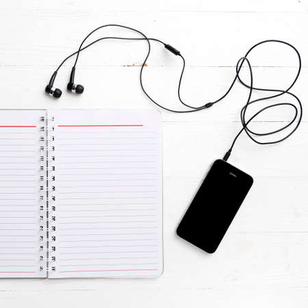 notepad and cellphone over white tableの写真素材