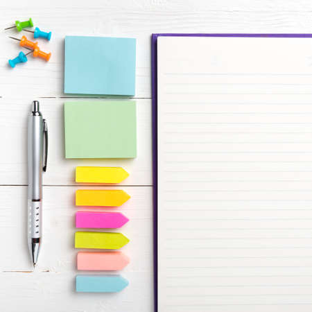 notepad with office supplies on white table view from aboveの写真素材