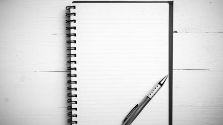 notepad with pen on white table black and white styleの写真素材