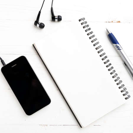 notepad and cellphone over white tableの写真素材