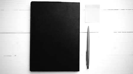 brown notebook and pen on white table view from above black and white tone color styleの写真素材