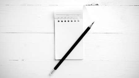 notepad with crumpled paper and pencil over white table black and white tone color style