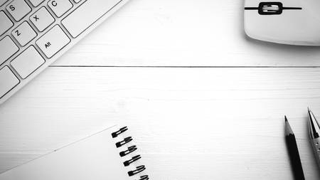 computer and notepad with pen on white table black and white styleの写真素材