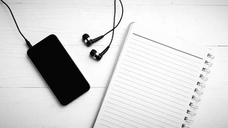 notepad and cellphone over white table black and white color tone styleの写真素材
