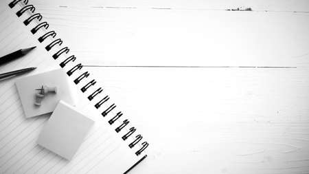 notepad with office supplies on white table view from above black and white styleの写真素材