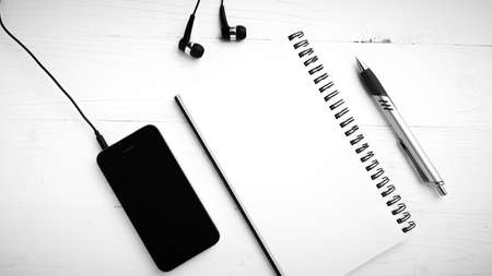 notepad and cellphone over white table black and white color tone styleの写真素材