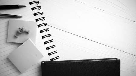 brown notebook with office supplies on white table view from above black and white styleの写真素材