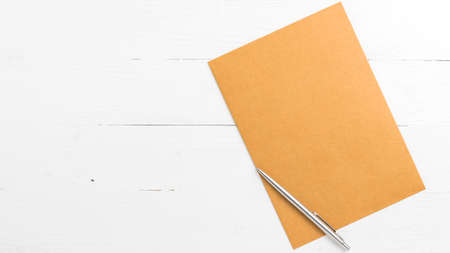 brown paper with pen on white table view from aboveの写真素材
