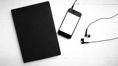 cellphone and notebook over white table black and white color tone styleの写真素材