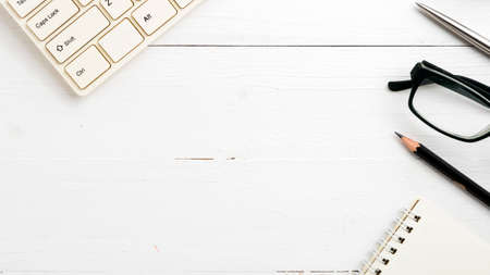 computer and notepad with pen on white tableの写真素材