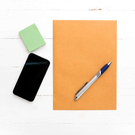 brown paper and smart phone on white tableの写真素材