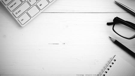 computer and notepad with pen on white table black and white styleの写真素材