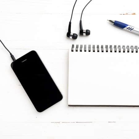 notepad and cellphone over white tableの写真素材