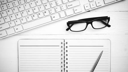 computer and notepad over white table black and white tone color styleの写真素材